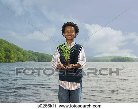 A boy holding grass View Large Photo Image Stock Photograph - A boy holding grass. Fotosearch