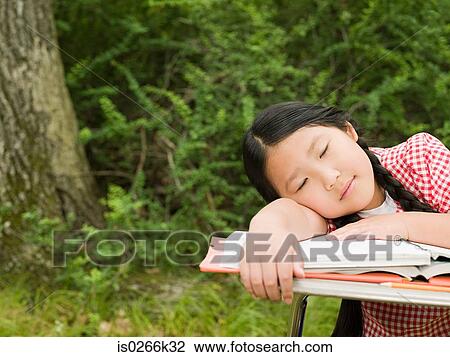 A girl asleep on a desk View Large Photo Image Stock Image - A girl asleep on a desk. Fotosearch