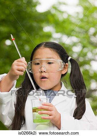 Stock Image - A girl doing an experiment. Fotosearch