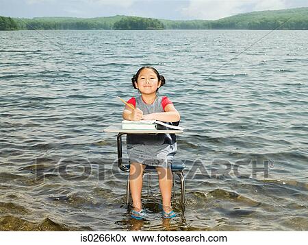 A girl sat at a desk in a lake View Large Photo Image Stock Photo - A girl sat at a desk in a lake. Fotosearch
