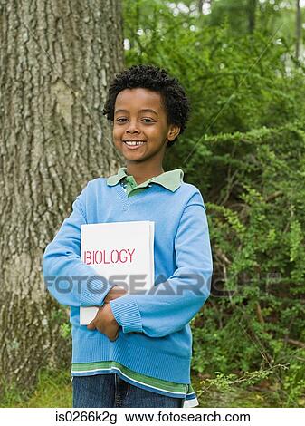 Portrait of a boy holding a book View Large Photo Image Stock Image - Portrait of a boy holding a book. Fotosearch