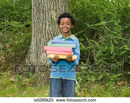Portrait of a boy holding a stack of books View Large Photo Image Stock Photography - Portrait of a boy holding a stack of books. Fotosearch