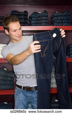 Stock Photo - Man shopping for a pair of jeans. Fotosearch
