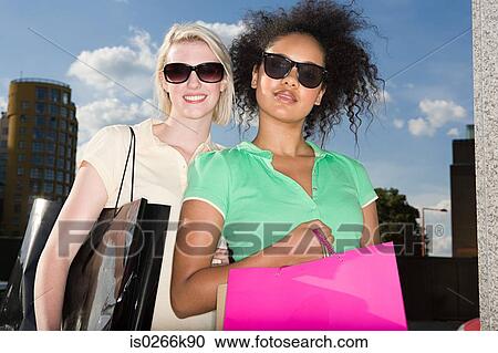 Two female friends with shopping bags View Large Photo Image Stock Image - Two female friends with shopping bags. Fotosearch