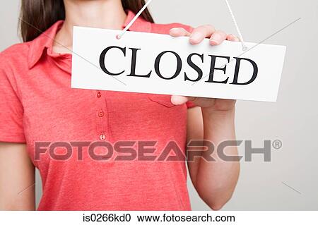 Stock Image - Woman holding a closed sign. Fotosearch