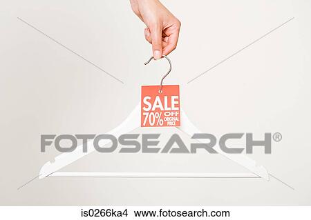 Woman holding a clothes hanger View Large Photo Image Picture - Woman holding a clothes hanger. Fotosearch