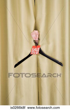 Stock Image - Woman holding a clothes hanger. Fotosearch