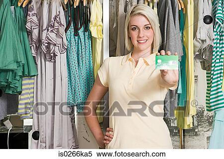 Woman holding a credit card in a clothes store View Large Photo Image Stock Photography - Woman holding a credit card in a clothes store. Fotosearch