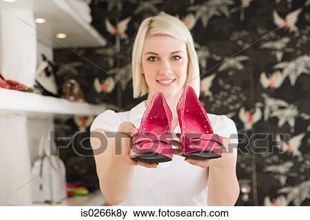 Woman holding a pair of high heeled shoes View Large Photo Image Stock Photo - Woman holding a pair of high heeled shoes. Fotosearch