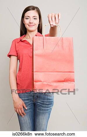 Picture - Woman holding a red shopping bag. Fotosearch