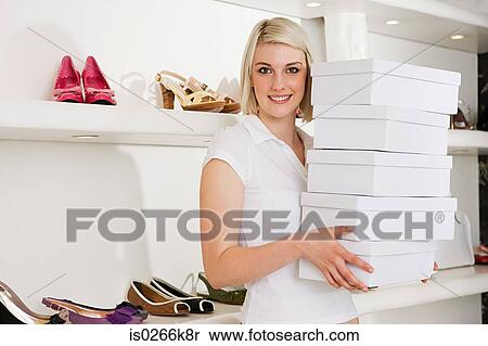 Stock Photography - Woman holding a stack of shoe boxes. Fotosearch