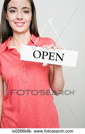 Stock Image - Woman holding an open sign. Fotosearch