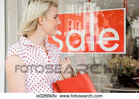 Woman looking at a shop sale View Large Photo Image Stock Photo - Woman looking at a shop sale. Fotosearch