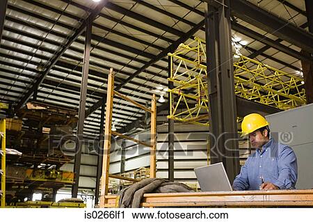 Man in warehouse with laptop View Large Photo Image Stock Image - Man in warehouse with laptop. Fotosearch