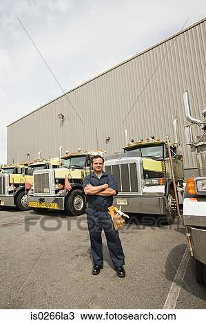 Stock Image - Worker by trucks. Fotosearch