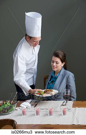 A chef serving a woman with a meal View Large Photo Image Stock Image - A chef serving a woman with a meal. Fotosearch