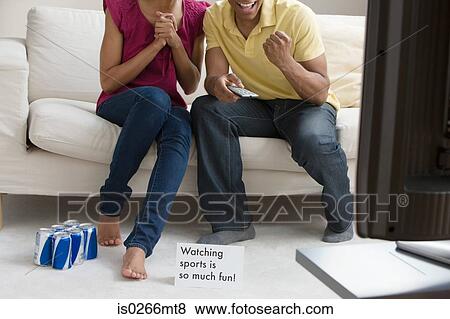A couple watching sport on the tv View Large Photo Image Stock Photo - A couple watching sport on the tv . Fotosearch