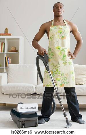 Stock Photograph - A man vacuum cleaning. Fotosearch