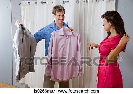 A woman helping a man choose a shirt View Large Photo Image Stock Photo - A woman helping a man choose a shirt. Fotosearch
