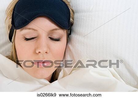 Sleeping woman wearing eye mask View Large Photo Image Stock Photo - Sleeping woman wearing eye mask. Fotosearch