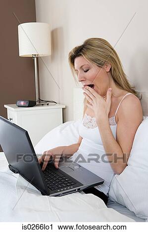 Woman in bed with laptop View Large Photo Image Stock Image - Woman in bed with laptop. Fotosearch