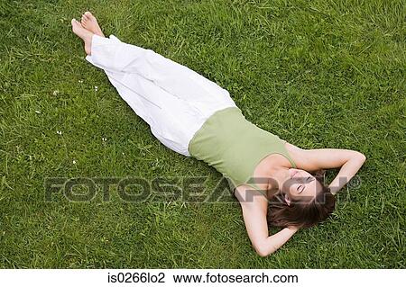 Woman lying on grass View Large Photo Image Stock Image - Woman lying on grass. Fotosearch