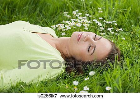 Woman lying on grass View Large Photo Image Stock Photo - Woman lying on grass. Fotosearch