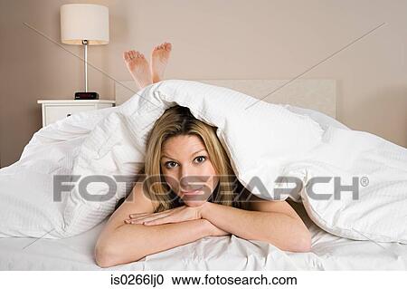 Woman under duvet View Large Photo Image Stock Image - Woman under duvet. Fotosearch