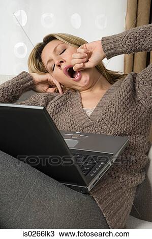 Yawning woman with laptop View Large Photo Image Stock Image - Yawning woman with laptop. Fotosearch