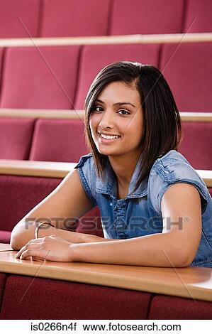 Stock Image - Female student in lecture theatre. Fotosearch