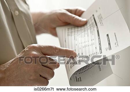 Stock Photograph - A man holding a bank statement. Fotosearch