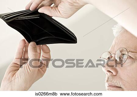 Stock Image - A man looking in an empty wallet. Fotosearch