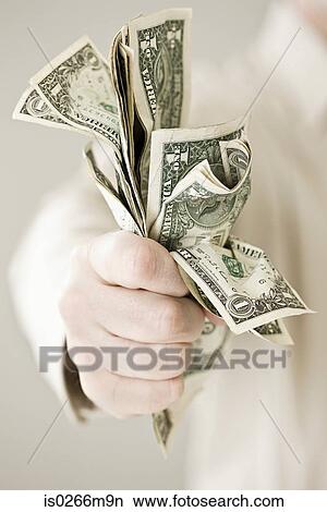 A person holding a bunch of dollars View Large Photo Image Picture - A person holding a bunch of dollars. Fotosearch
