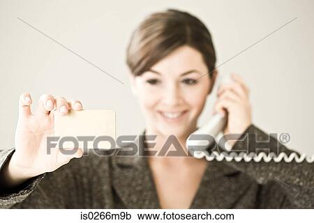 Stock Image - A woman buying on a credit card over the phone. Fotosearch
