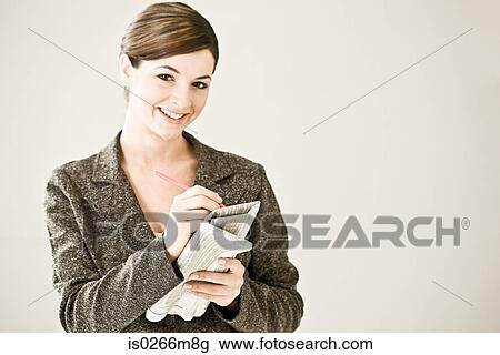 A woman writing on a financial paper View Large Photo Image Stock Image - A woman writing on a financial paper. Fotosearch