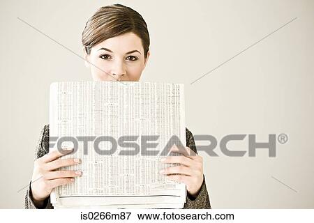 Portrait of a woman holding a newspaper View Large Photo Image Stock Photo - Portrait of a woman holding a newspaper. Fotosearch