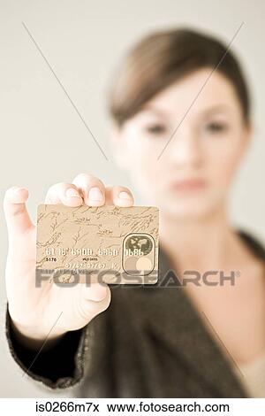 Stock Photo - Young woman holding a credit card. Fotosearch