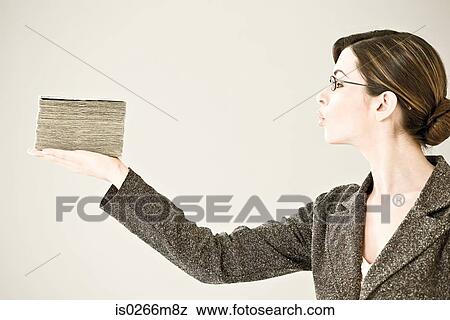 Young woman holding a stack of banknotes View Large Photo Image Stock Photo - Young woman holding a stack of banknotes. Fotosearch