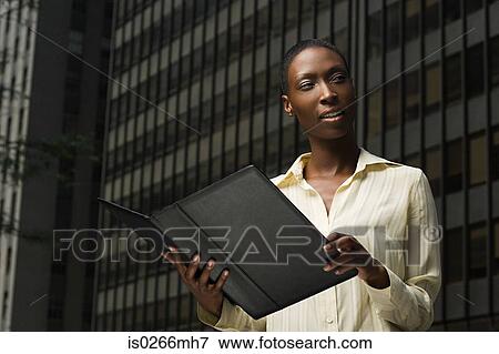 Businesswoman looking at a file View Large Photo Image Stock Photo - Businesswoman looking at a file. Fotosearch
