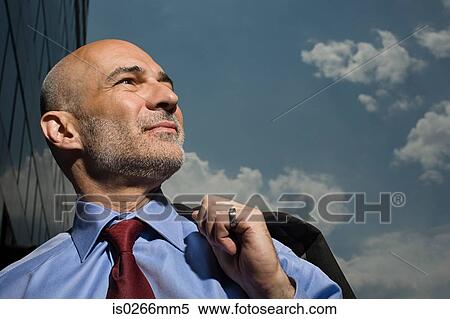 Grinning businessman and a cloudy sky View Large Photo Image Stock Photography - Grinning businessman and a cloudy sky. Fotosearch
