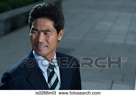 Stock Image - Japanese businessman on a sidewalk. Fotosearch