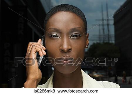 Serious looking woman using a cellular phone View Large Photo Image Stock Photo - Serious looking woman using a cellular phone. Fotosearch