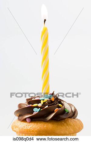 Birthday candle on a cup cake View Large Photo Image Picture - Birthday candle on a cup cake . Fotosearch