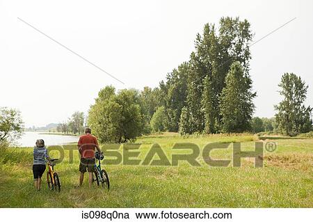 Couple in countryside with bicycles View Large Photo Image Stock Image - Couple in countryside with bicycles. Fotosearch