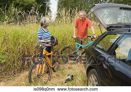 Couple with car and bicycles View Large Photo Image Picture - Couple with car and bicycles. Fotosearch