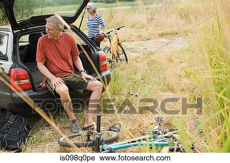 Couple with car and bicycles View Large Photo Image Stock Image - Couple with car and bicycles. Fotosearch