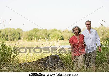 Mature couple in field View Large Photo Image Stock Photo - Mature couple in field. Fotosearch