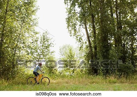 Woman riding bicycle View Large Photo Image Stock Photograph - Woman riding bicycle. Fotosearch