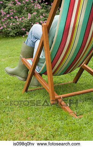 Gardener relaxing in a deckchair View Large Photo Image Stock Photo - Gardener relaxing in a deckchair. Fotosearch