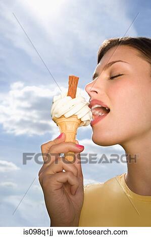 Young woman eating ice cream View Large Photo Image Stock Image - Young woman eating ice cream. Fotosearch
